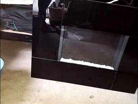 Freecycle Wall-mounted flame-effect black glass fire.